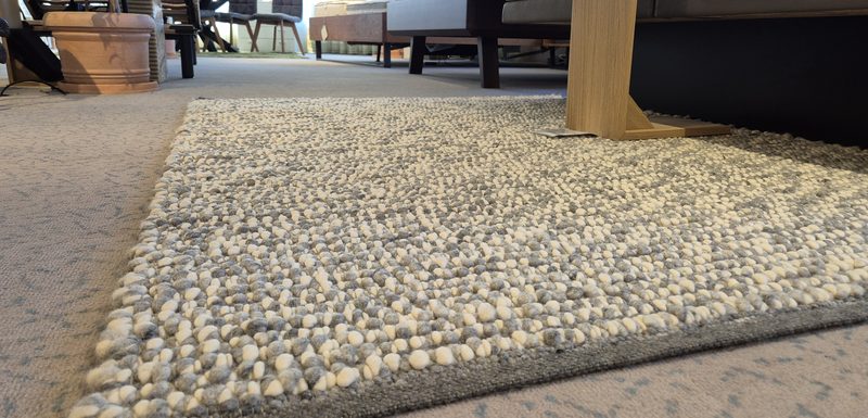 Handwebeteppich auf dem Boden des Showrooms, die Schlingen der Oberfläche sind zu erkennen